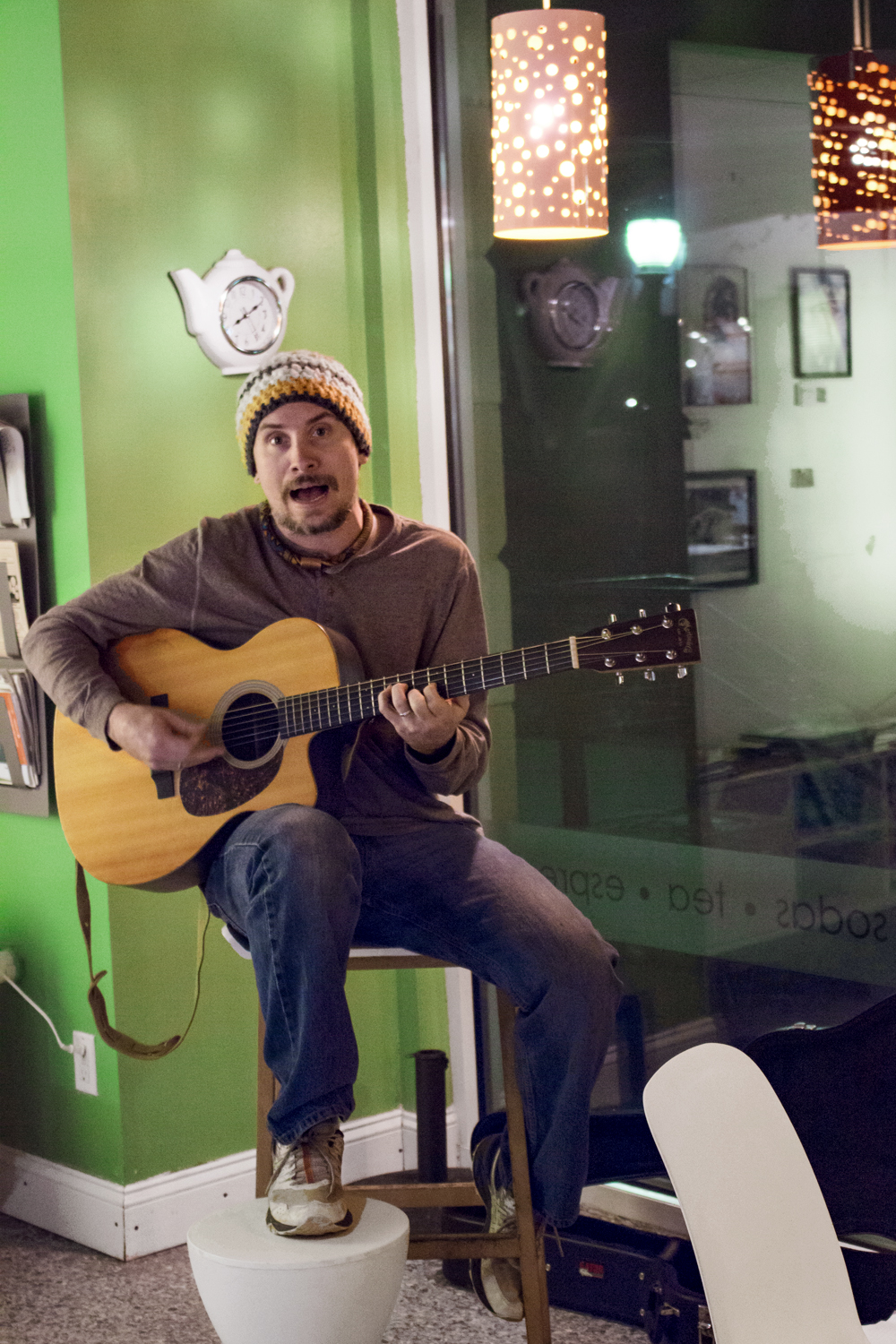 Musician Adam Kiraly playing guitar at O-Cha