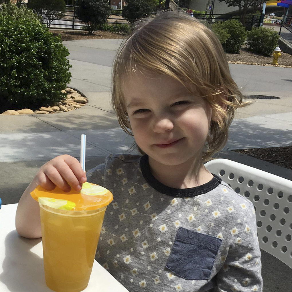 Boy drinking juice outside of O-Cha