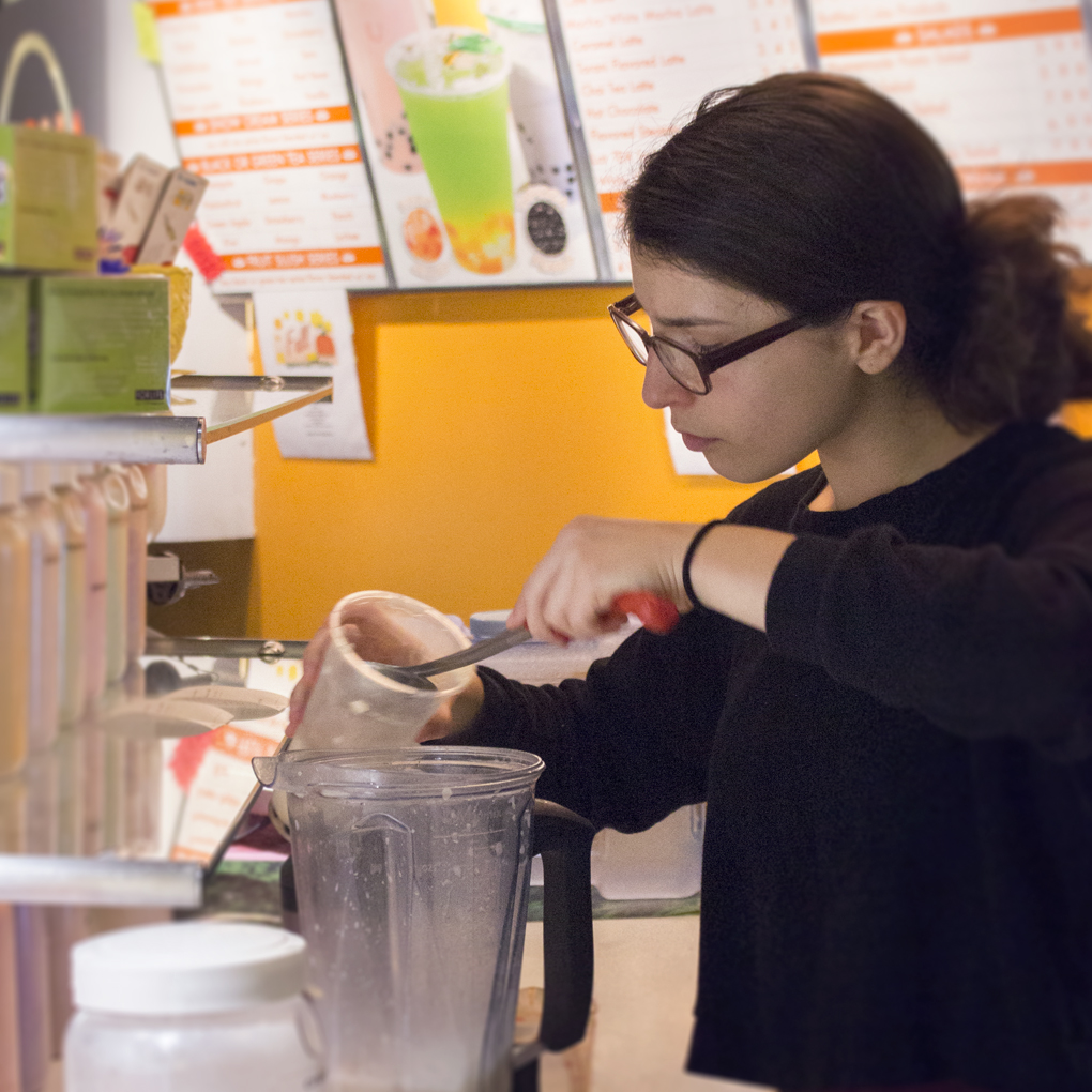 Girl using blender to make smoothie