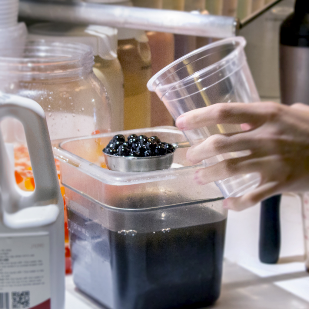 Scooping tapioca jellies into a cup for bubble tea